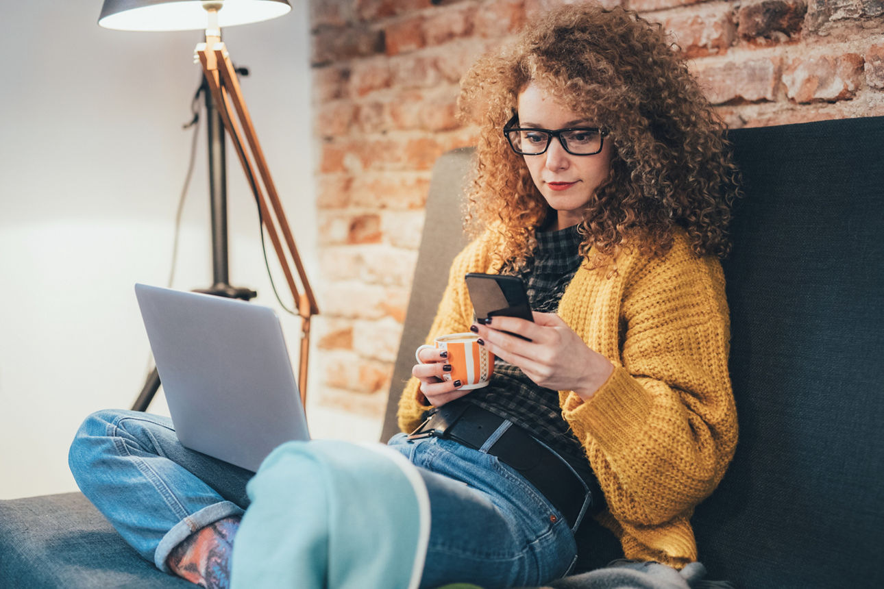 Frau surft im Internet und trinkt Kaffee zu Hause