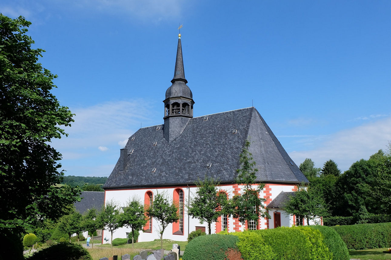 KI generiertes Bild von einer Kirche auf einen Hügel mit Windrädern und Wiesen im Hintergrund.