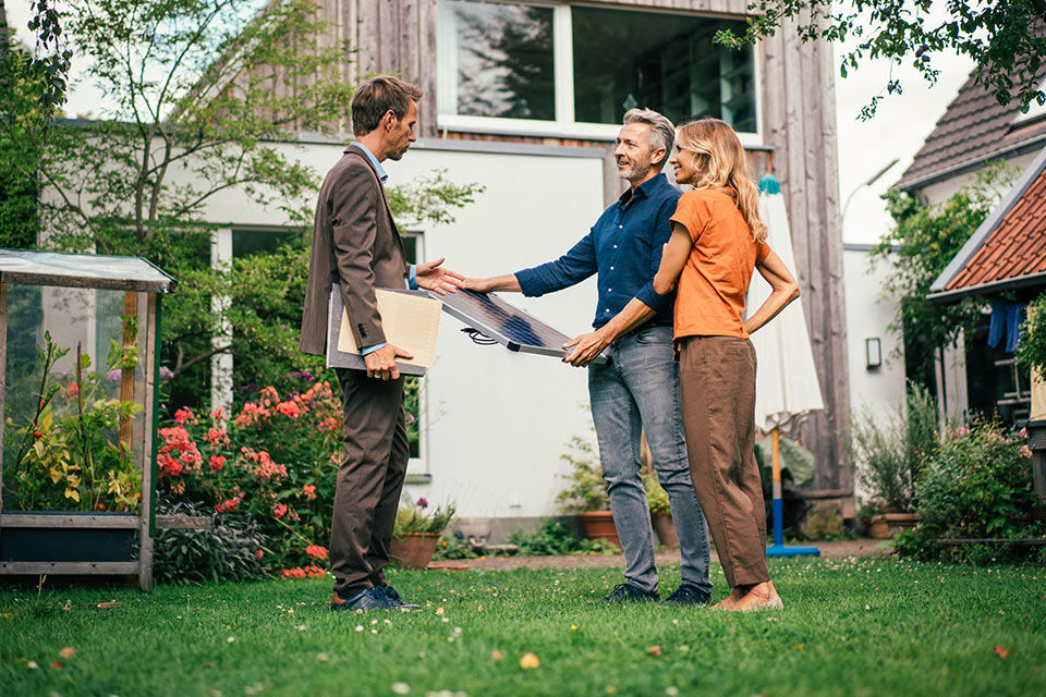 Ein Paar mit einem Berater im Garten ihres Hauses