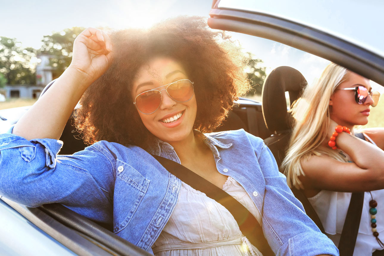 Zwei Frauen sitzend lachend in einem Auto