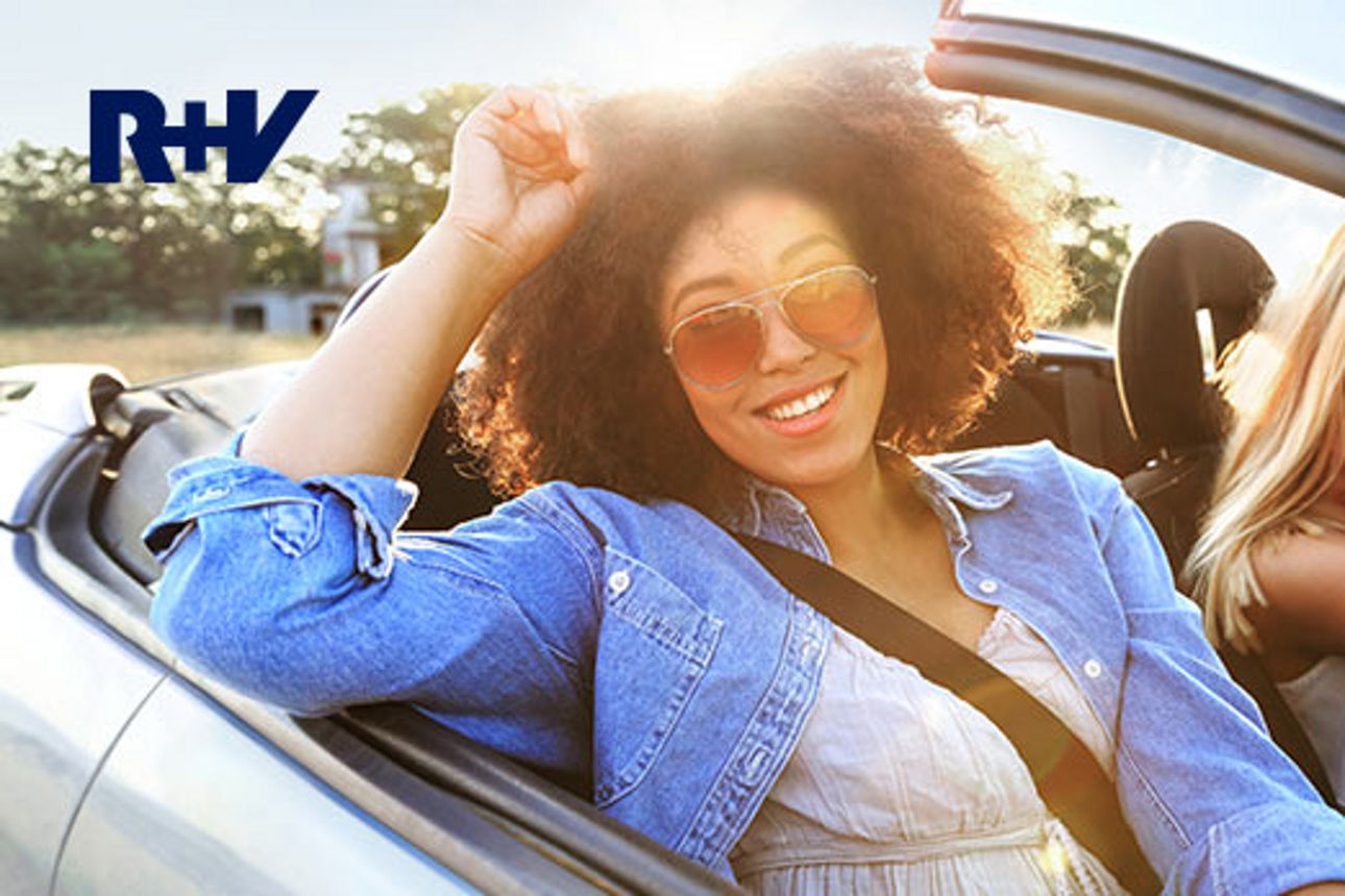 Junge Frau mit Sonnenbrille sitzt im Auto