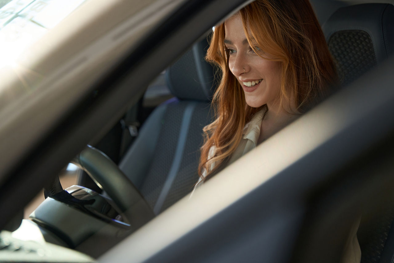 Autofahrerin informiert über die Leistungen ihrer KFZ-Versicherung
