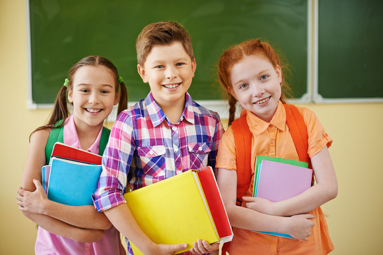 3 Kinder vor einer Tafel in der Schule
