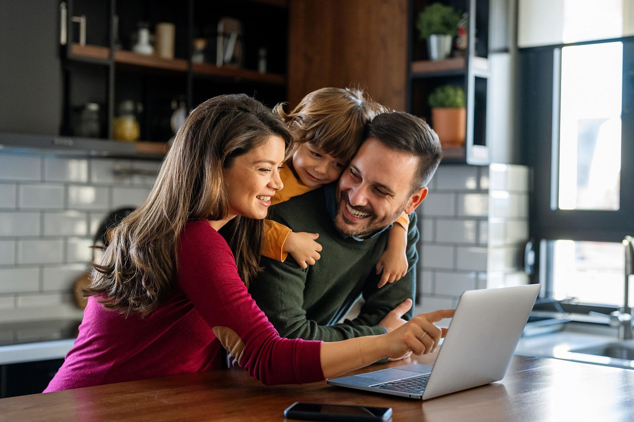 Eine Familie informiert sich am Laptop darüber, wie sie die Kinderbetreuungskosten von der Steuer absetzen können.