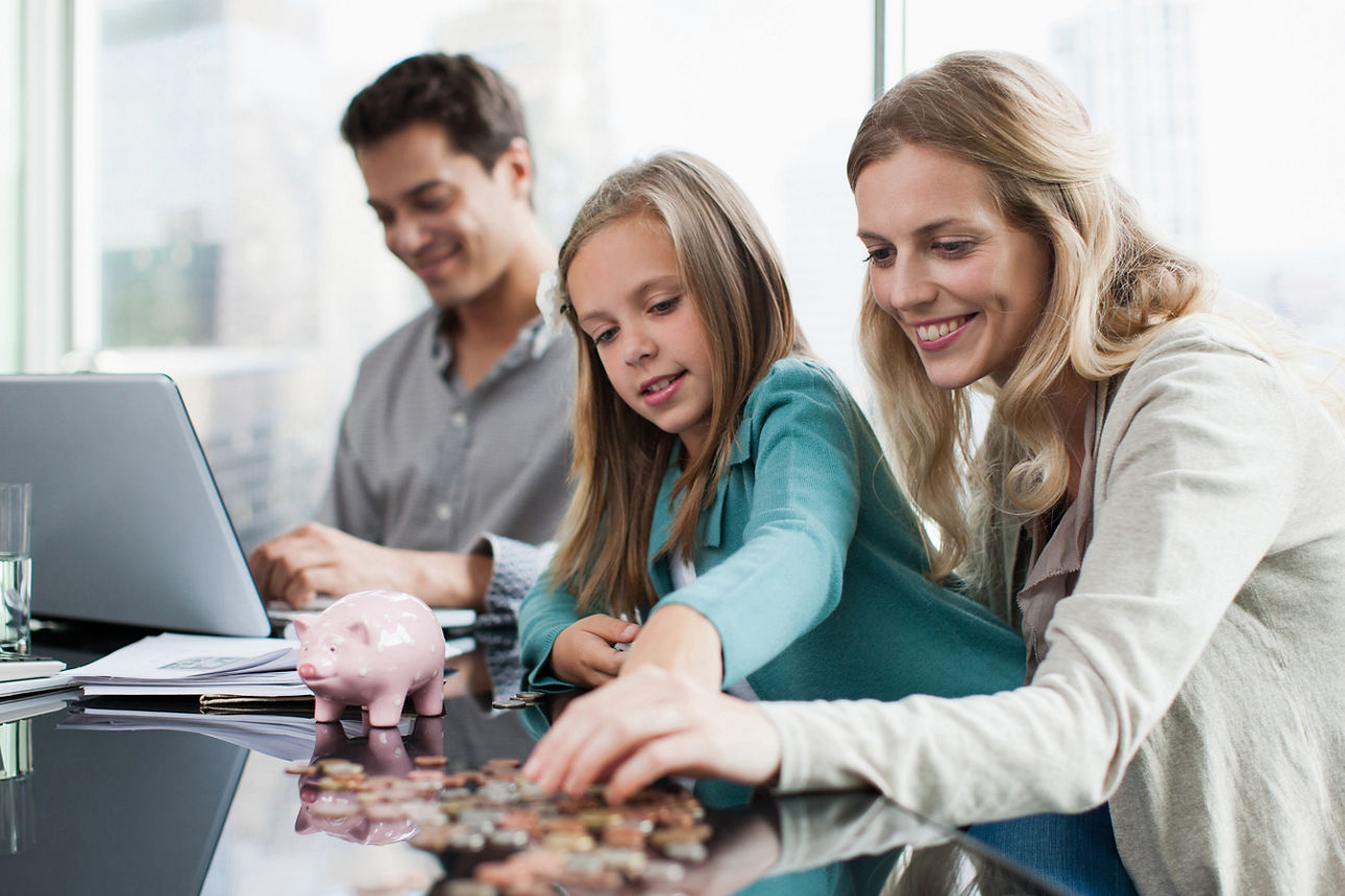 Familie zählt gemeinsam Geld – Symbolbild für kluge Anlage mit Kindergeld.
