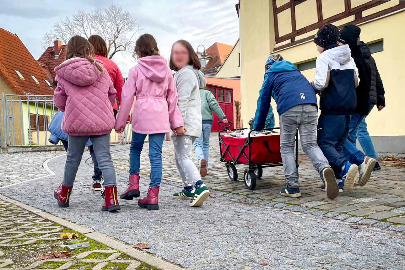 Kinder des Kinderschutzbund Eisenberg mit Bollerwagen auf einem Weg