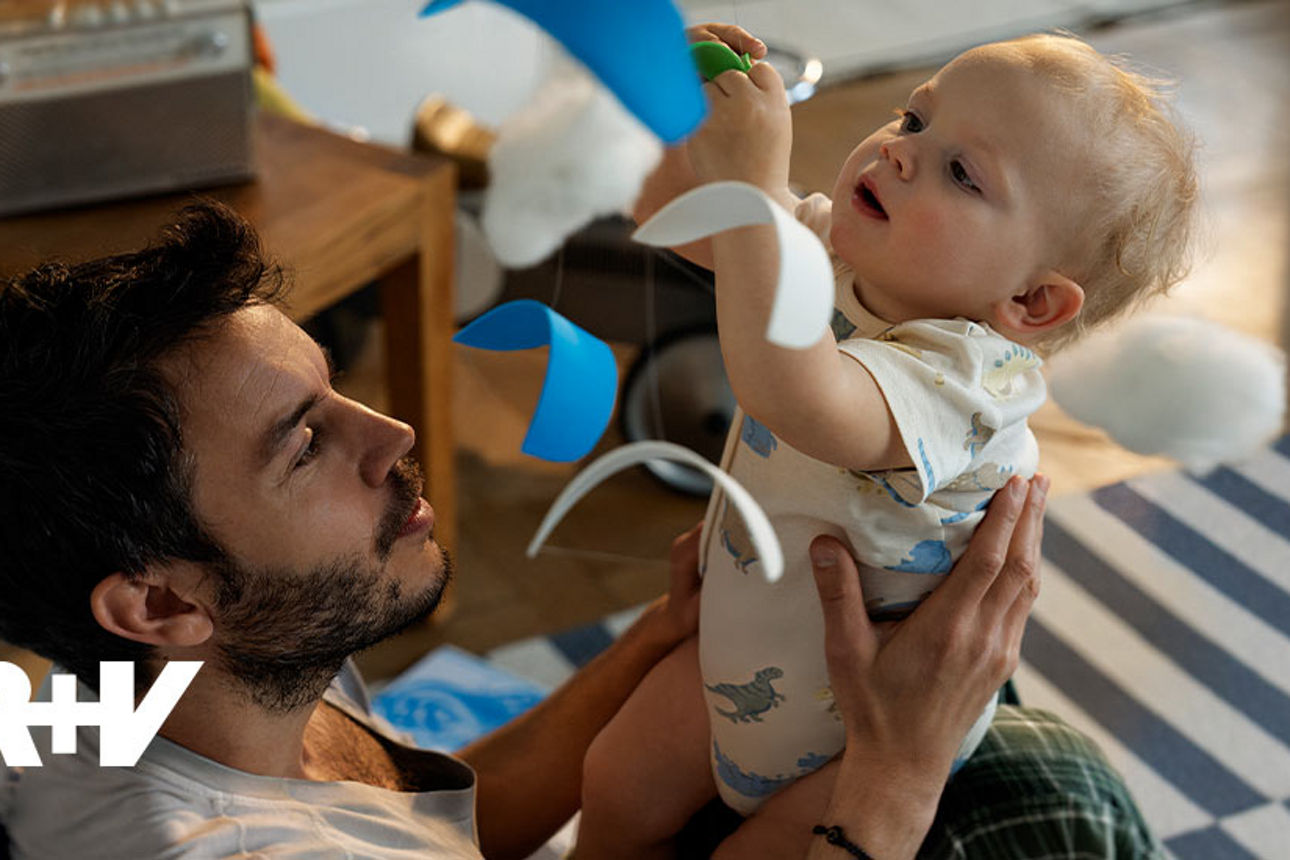 Vater sitzt mit seinem Kind auf der Couch