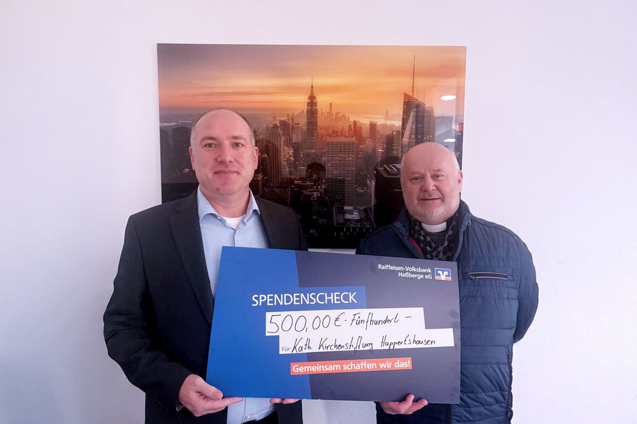 Alexander Rauschert von der Raiffeisen-Volksbank Haßberge eG übergibt die Spenden an die Kirchenstiftung Happertshausen