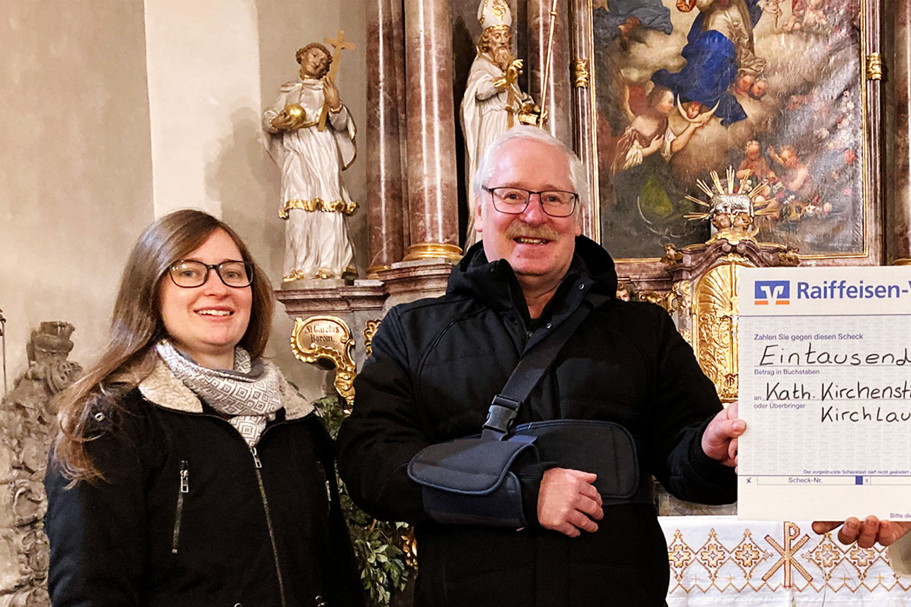 Johanna Krebs von der Raiffeisen-Volksbank Haßberge eG übergibt einen Spendenscheck an die Kath. Kirchenstiftung Kirchlauter