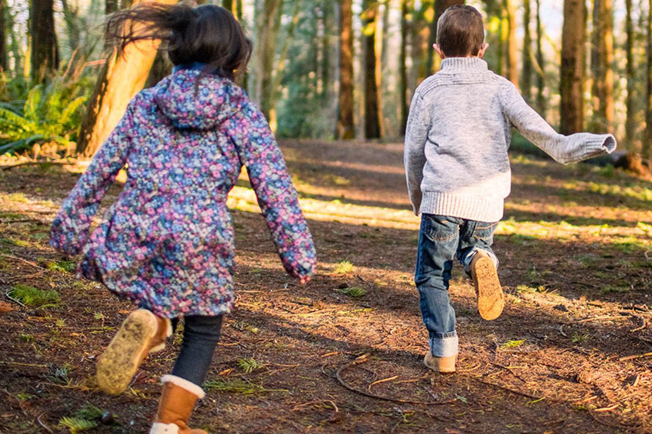 Zwei Kinder rennen im Wald