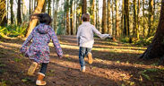 Zwei Kinder laufen durch den Wald