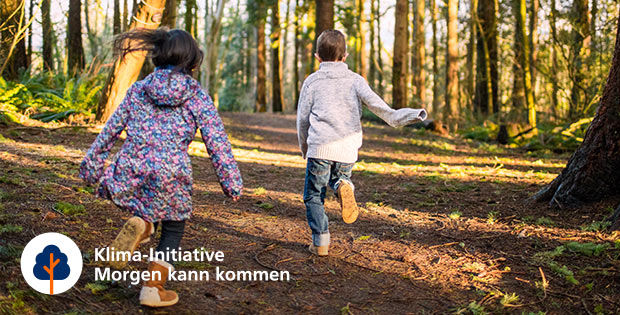 Ein Mädchen und ein Junge laufen durch den Wald