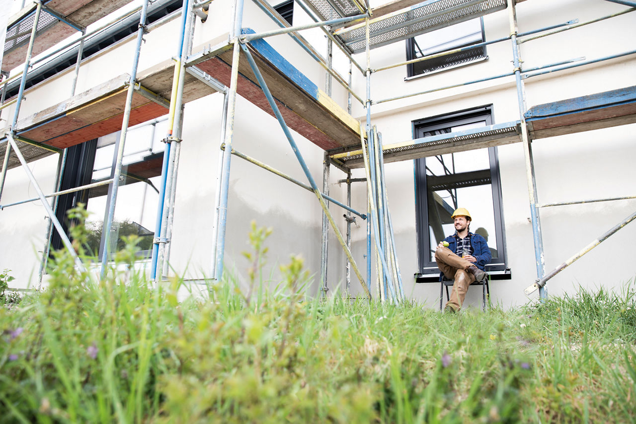 Glücklicher Mann beim Haus modernisieren