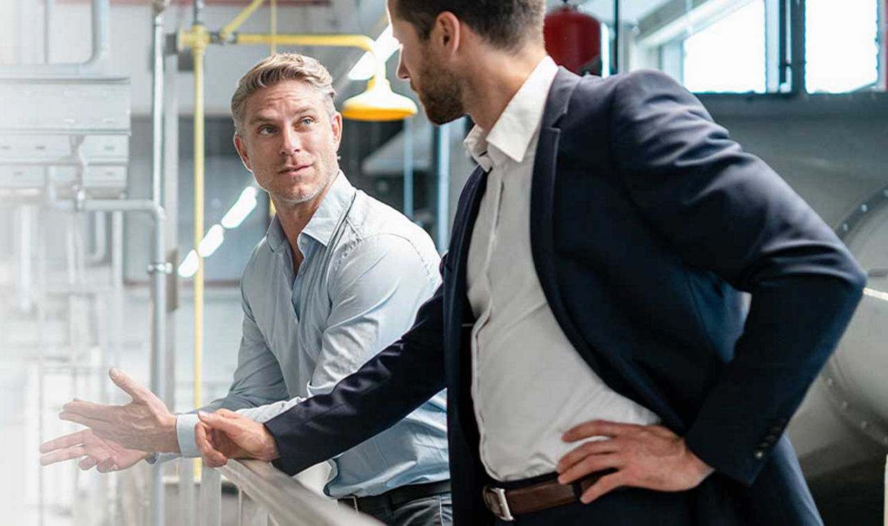 Liquiditätsmanagement - Zwei Männer unterhalten sich in einem Lager