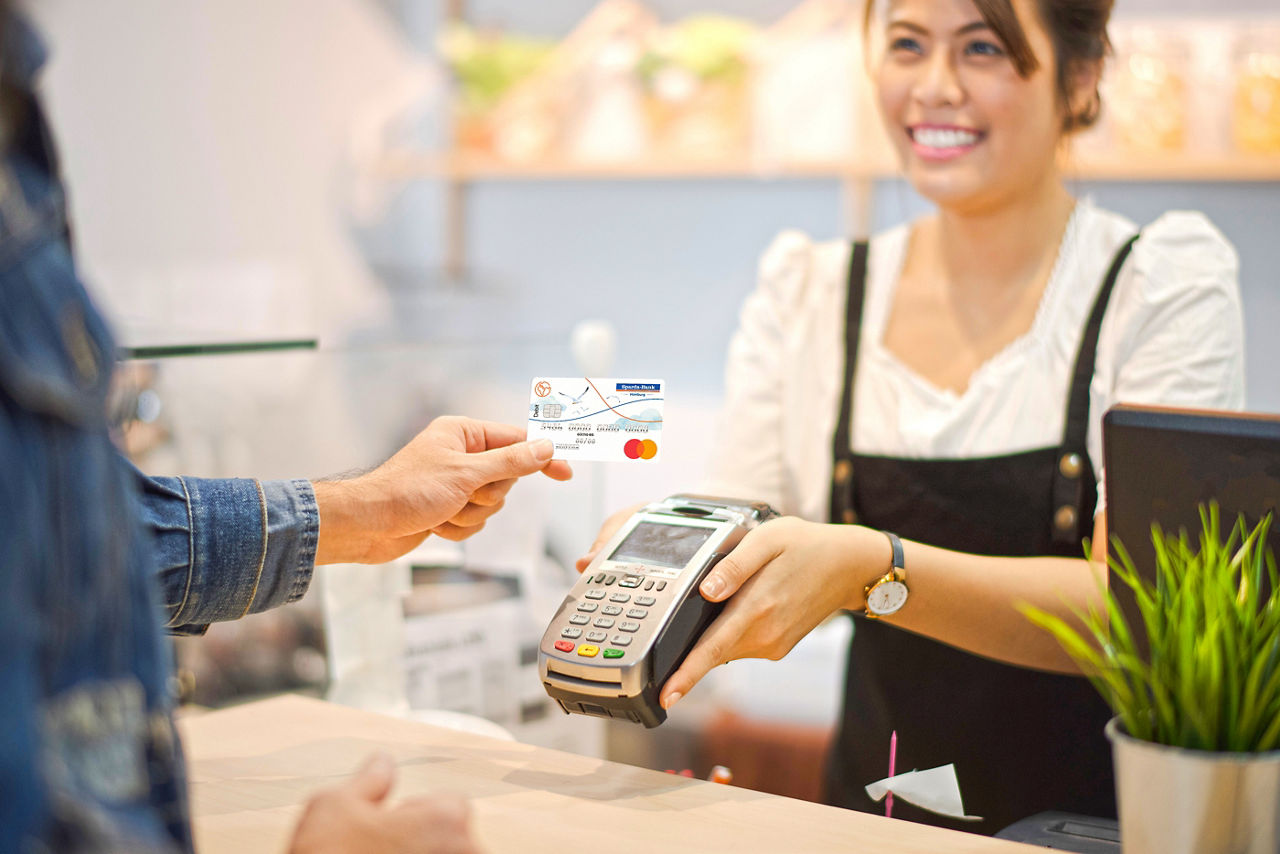 Frau bezahlt mit ihrer Bankkarte kontaktlos
