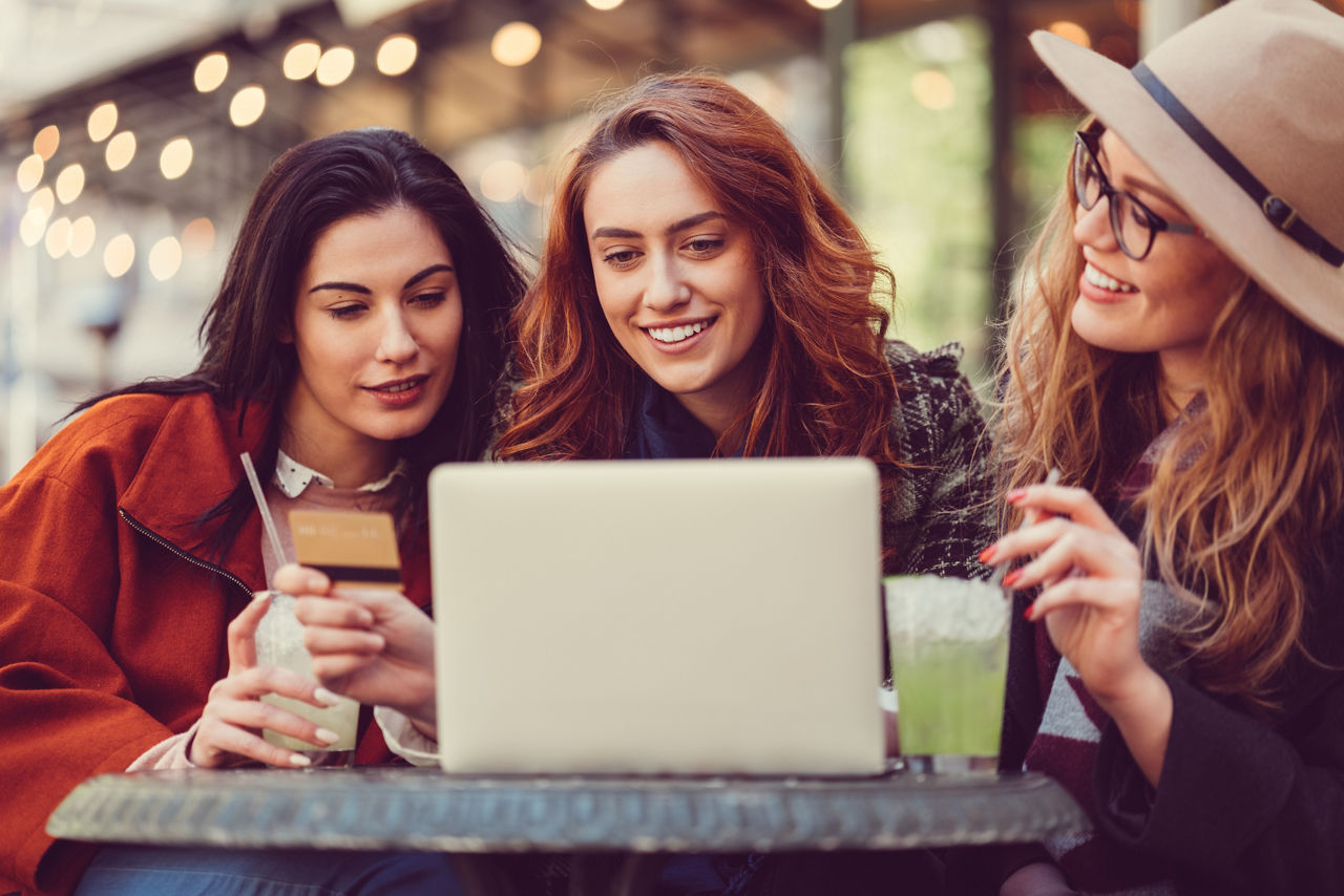 Freundinnen beim Online-Shopping mit Kreditkarte