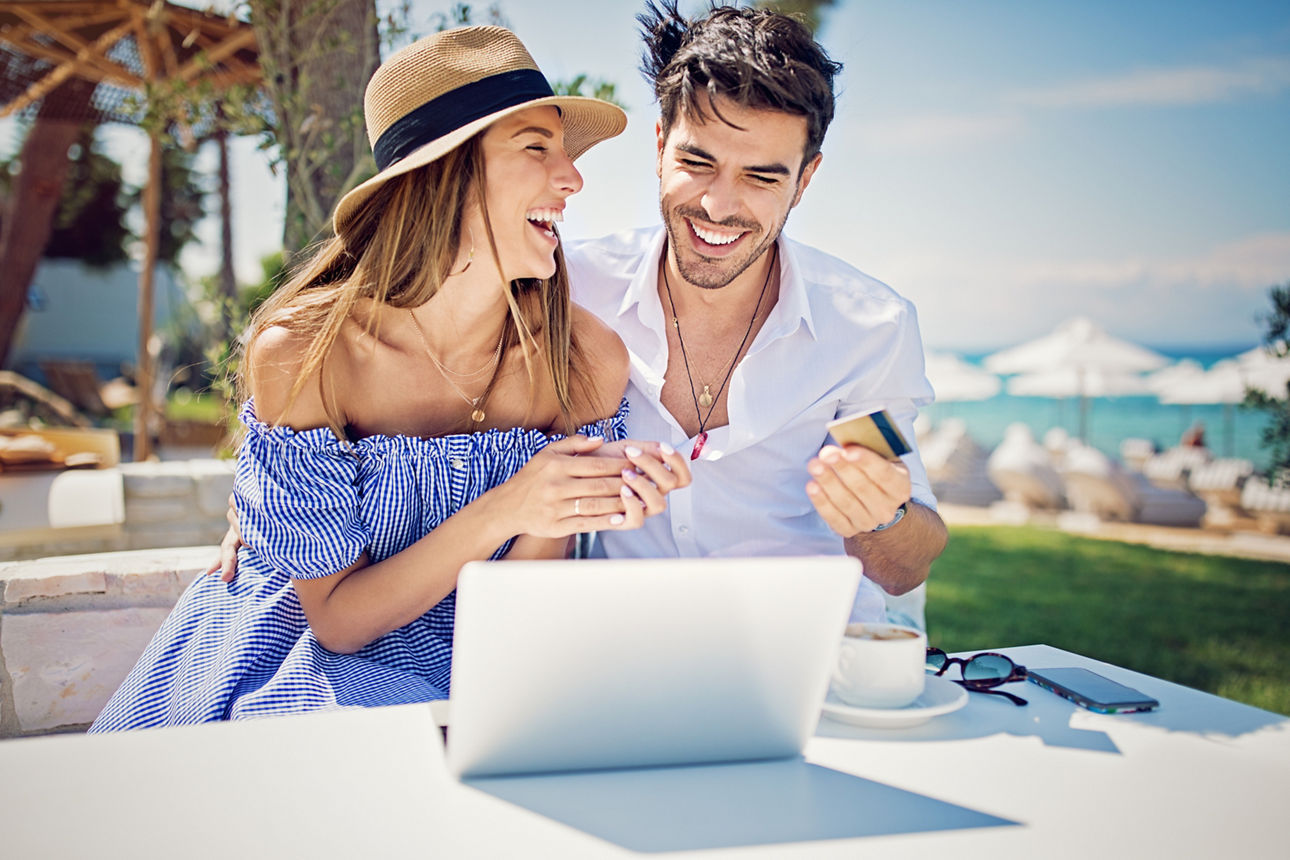 Junges Paar nutzt OnlineBanking in der Strandbar
