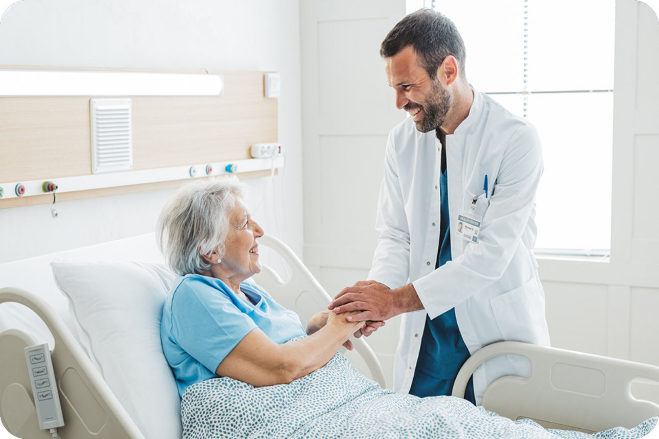 Ein Mann ist bei einer Patienten im Krankenzimmer.