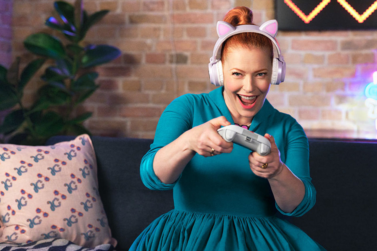 Eine Frau sitzt auf dem Sofa und spielt Videospiele