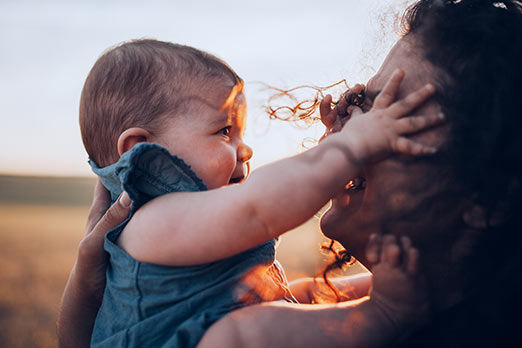 Junge Frau mit Baby in der Abendsonne