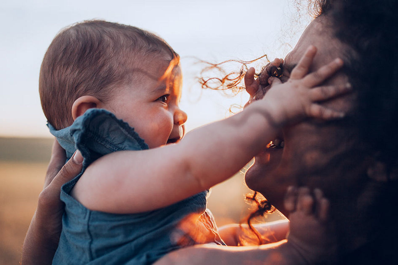 Junge Frau mit Baby in der Abendsonne