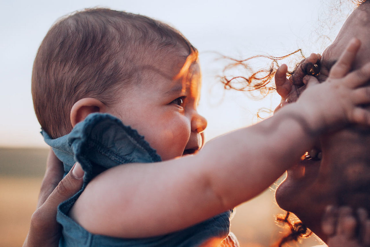 Junge Frau mit Baby in der Abendsonne