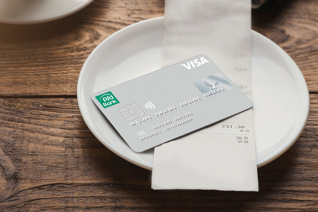 silberne Kreditkarte liegt auf einem Teller mit Rechnung im Restaurant