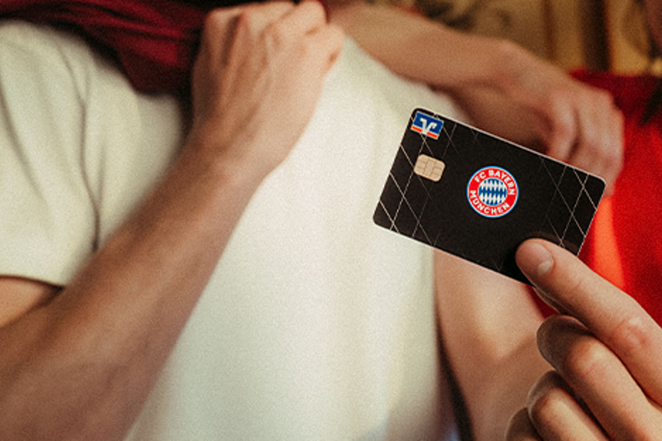 Eine Frau und ein Mann schauen auf die Kreditkarte im exklusiven FC Bayern Sonderdesign