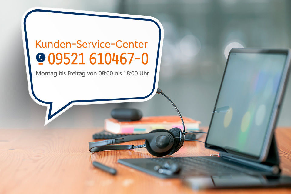 Telefinnummer 09521 610467-0 des Kunden-Service-Centers vor einem Laptop und einem Headset