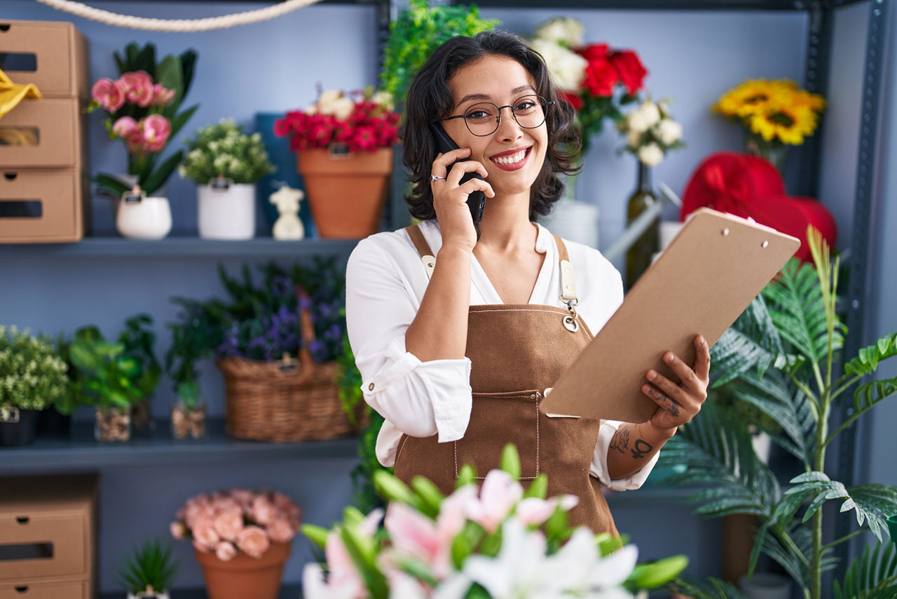 Eine Blumenhändlerin steht in ihrem Blumenladen