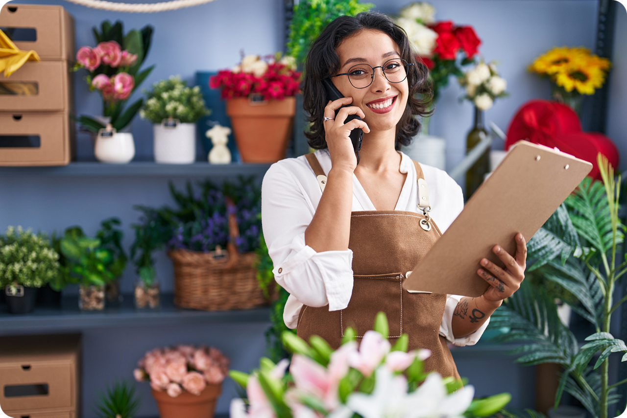 Eine Blumenhändlerin steht in ihrem Blumenladen