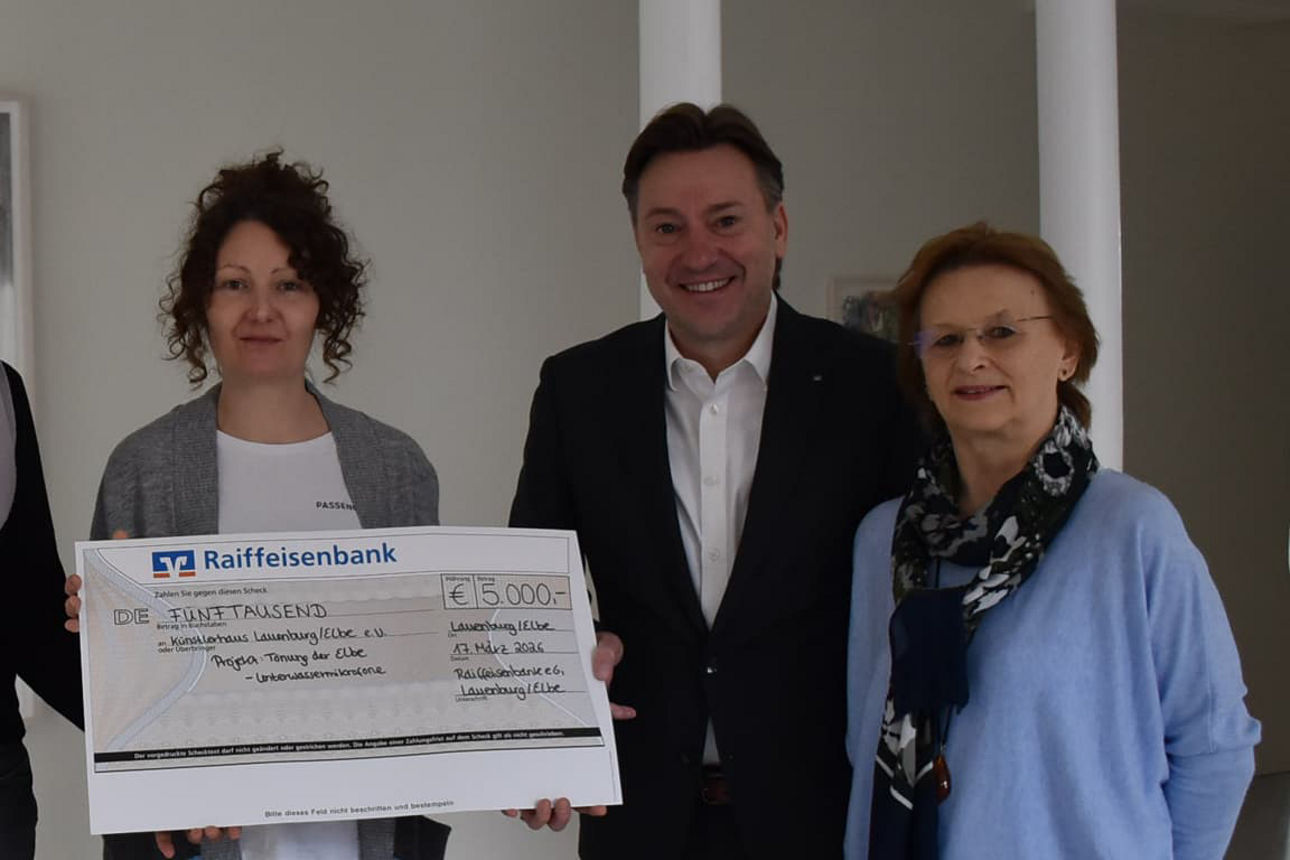 Künstlerin und Vertreterinnen vom Künstlerhaus Lauenburg/Elbe und Herr Göthling (Raiffeisenbank eG) vor einem Kunstwerk