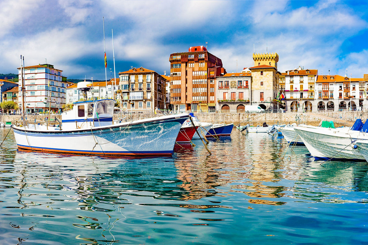Blick auf Boote die vor einer spanischen Küstenstadt liegen