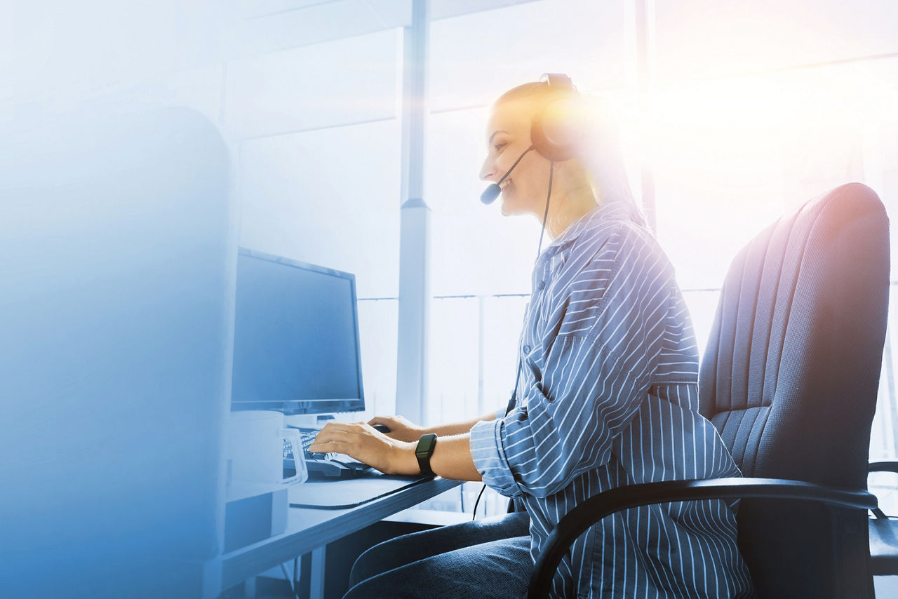 Frau mit Headset am PC