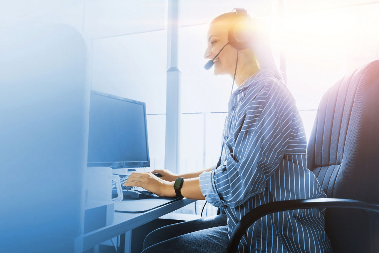 Frau mit Headset am PC