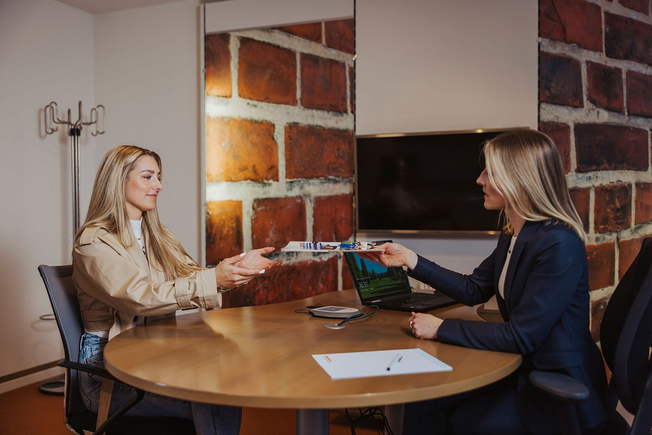 Zwei schön gekleidete Frauen sitzen an einem Tisch in einem Büro 