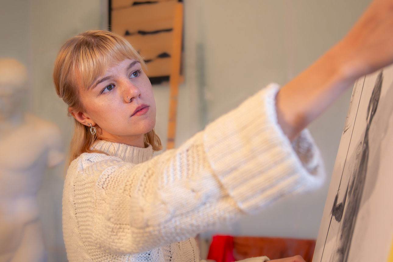 Eine Frau steht vor einer Leinwand.