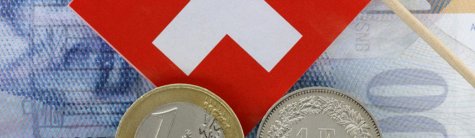 Schweizer Flagge liegt auf einem 100 Franken Schein. Darunter befindet sich eine 1-Euro-Münze und eine 1-Franken Mü