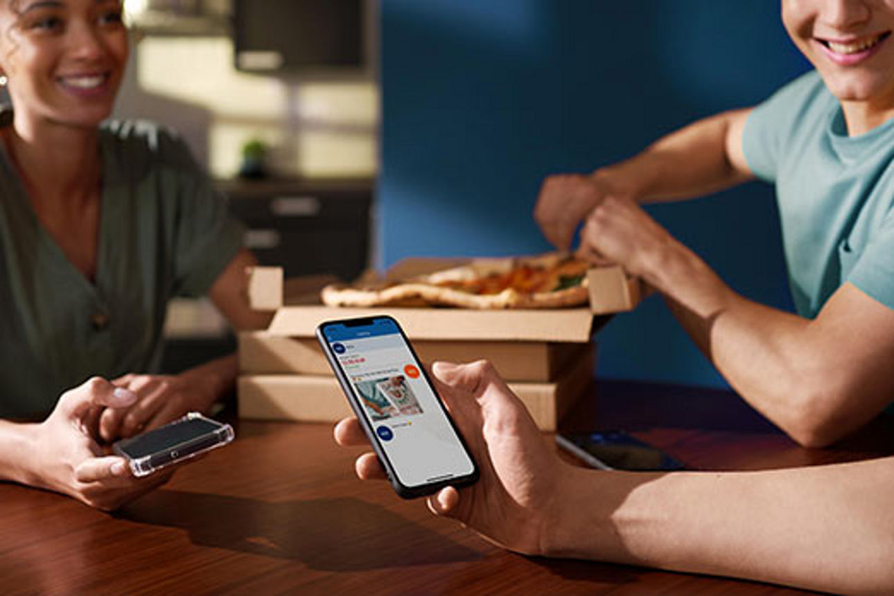 Eine Person sendet mit Ihrem Smartphone und  Kwitt einer anderen Person Geld aufs Smartphone