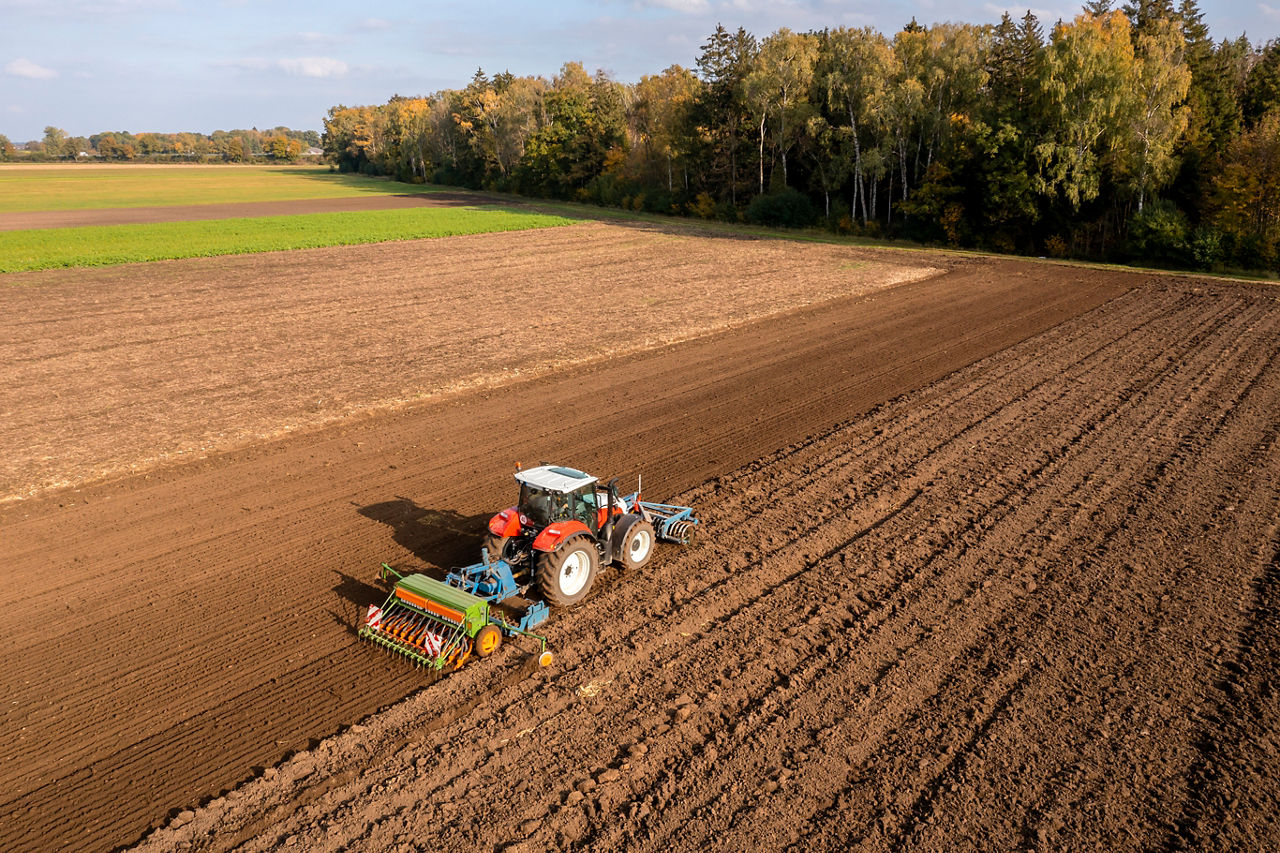 Ein Traktor fährt auf einem Feld und baut Saatgut an. Foto: Getty Images 2087168851.