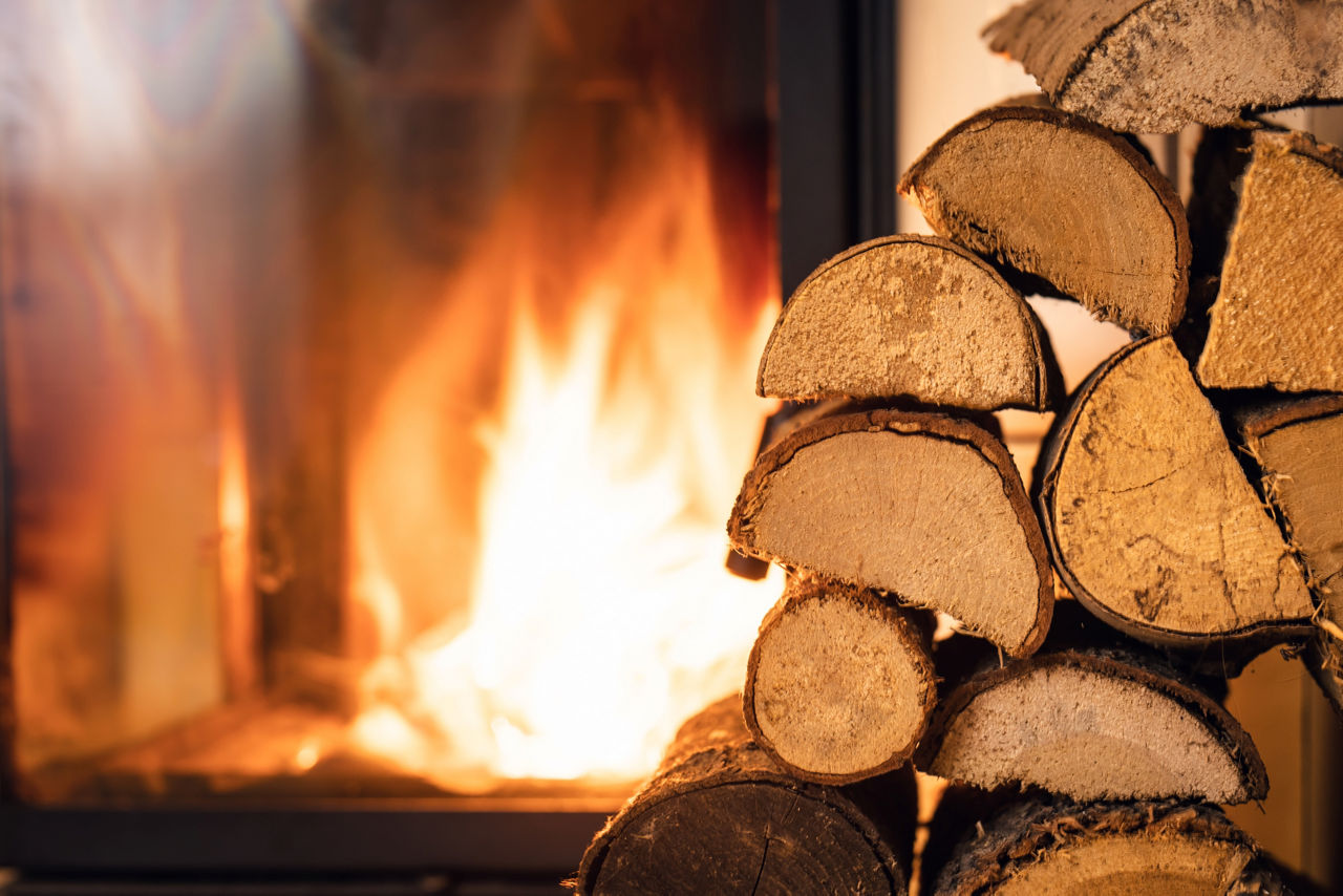 Vor einem Kamin steht Holz. Foto: Getty Images.