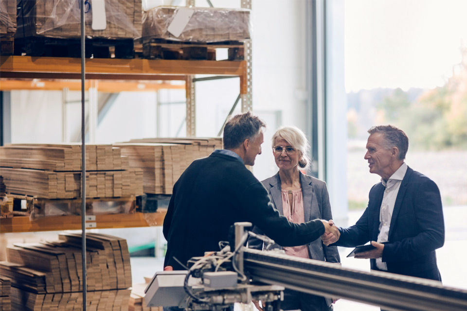 Bankberater bei einem Beratungsgespräch in einer Lagerhalle
