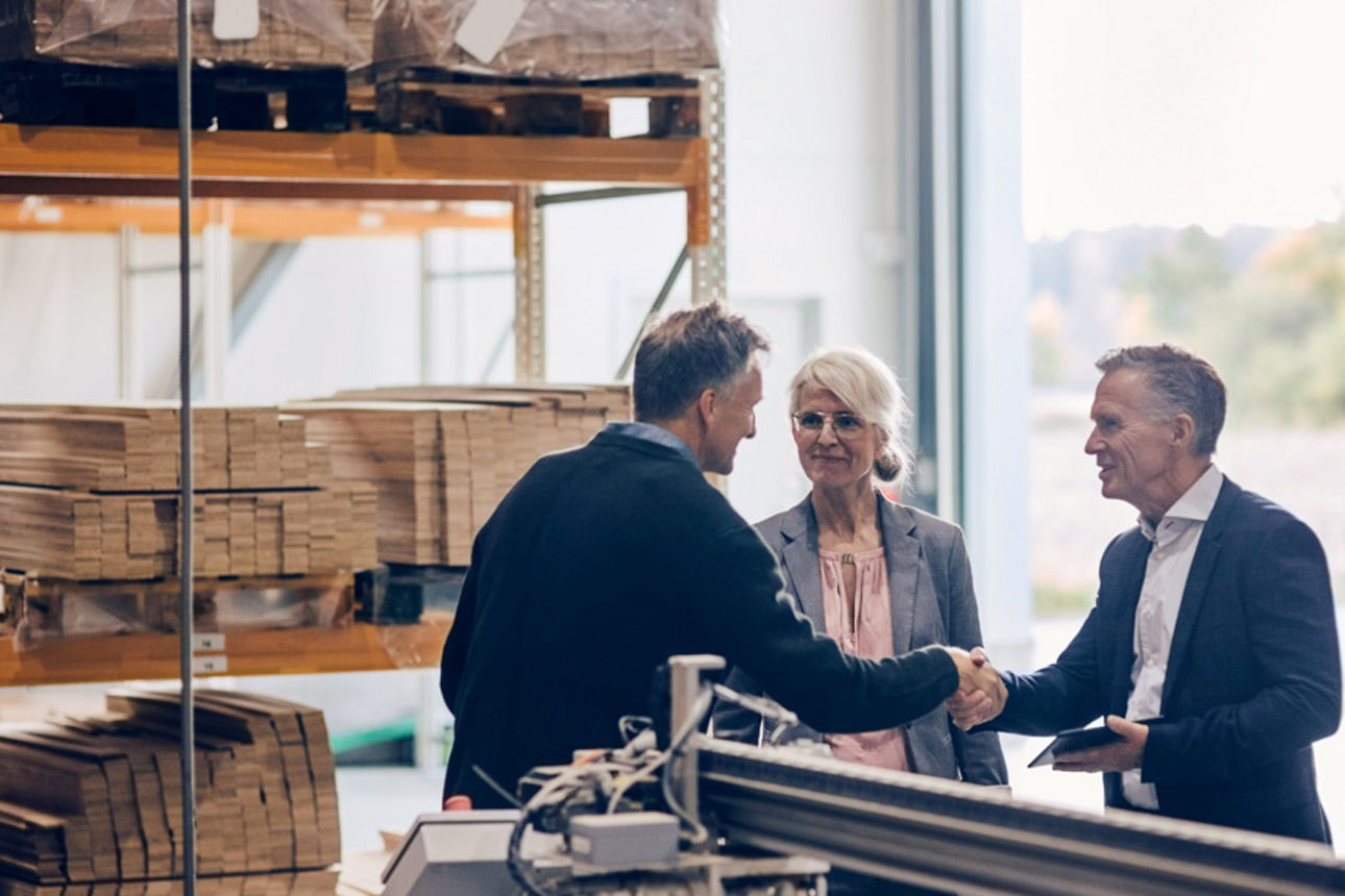 Bankberater bei einem Beratungsgespräch in einer Lagerhalle