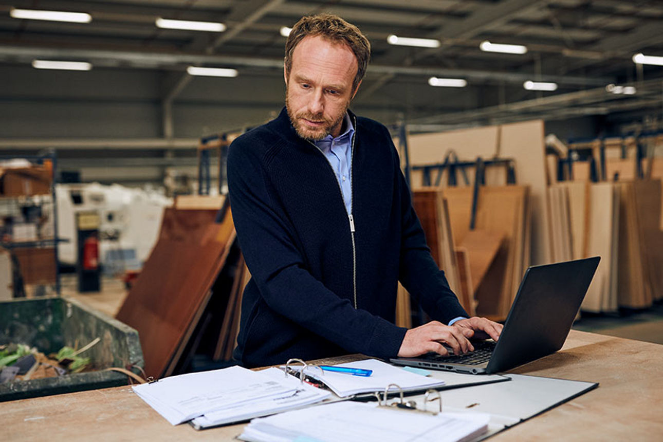 Mann überprüft Daten am Laptop