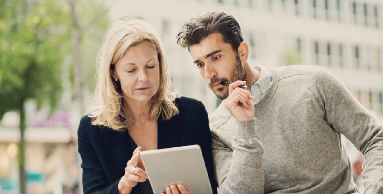Frau und Mann schauen in ein Tablet