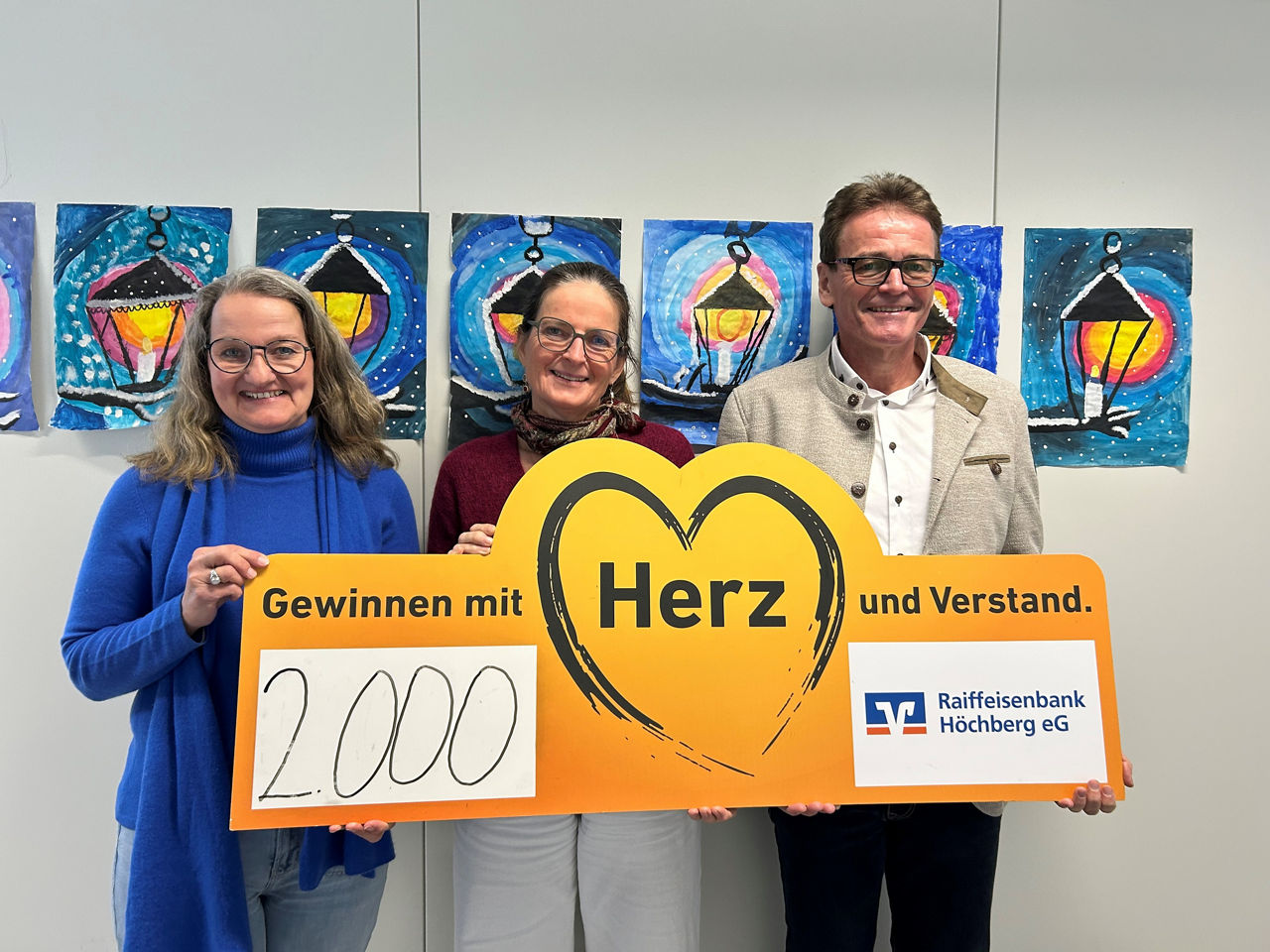 Zwei Damen und ein Herr mit einem provisorischen Scheck über 2.000 Euro.