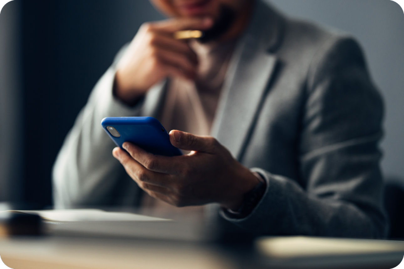 Person mit Anzug hält Telefon in der Hand