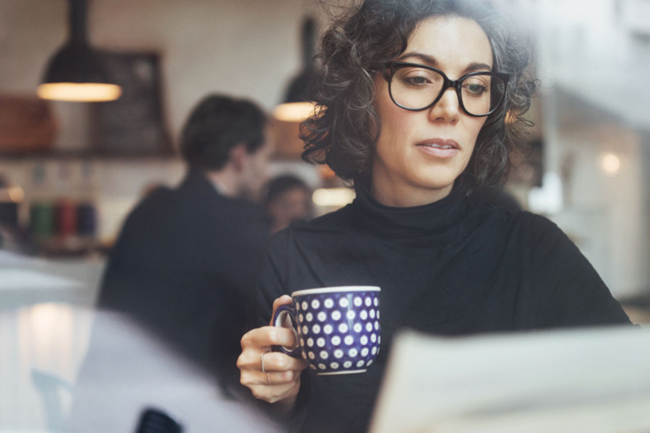 Weibliche Geschäftsfrau liest eine Zeitung im Café