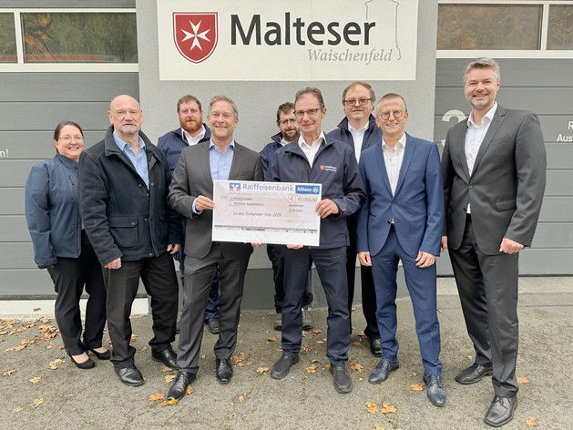 Die Malteser halten den Spendenscheck in der Hand