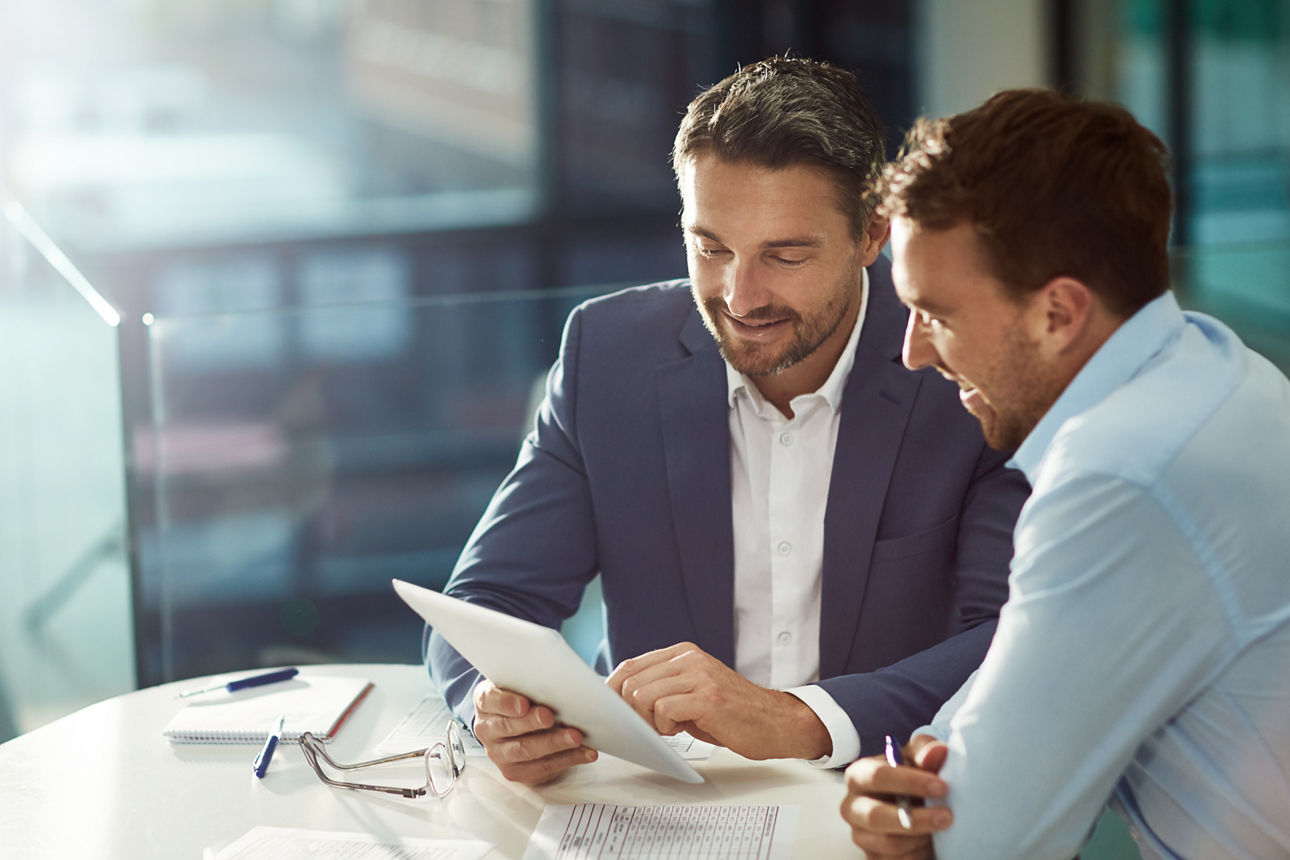 Zwei Business Männer sitzen in einem Meetingraum und sprechen über eine Haftpflichtversicherung für Manager eines Gewerbes